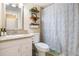 Inviting bathroom featuring a vanity, decorative shelves, a toilet, and a shower with curtain and greenery at 482 Southpark Rd, Highlands Ranch, CO 80126