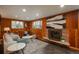 Basement boasts wood paneling, a decorative fireplace, and comfortable seating at 5982 S Aberdeen St, Littleton, CO 80120