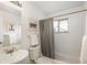 Bright bathroom features a vanity sink, toilet, shower with gray tile and art at 5982 S Aberdeen St, Littleton, CO 80120
