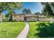 Well-maintained brick home featuring a lush, green lawn and mature shade trees at 5982 S Aberdeen St, Littleton, CO 80120