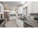 Bright kitchen with stainless steel appliances, granite counters, and white cabinetry at 5982 S Aberdeen St, Littleton, CO 80120