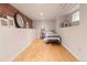 Basement bedroom features a minimalist design with exposed brick and hardwood floors at 2377 Cherry St, Denver, CO 80207