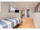 Basement bedroom features a minimalist design with exposed brick and hardwood floors at 2377 Cherry St, Denver, CO 80207