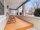 Inviting front porch with classic wood floors and rocking chairs, perfect for relaxing and enjoying the neighborhood view at 2377 Cherry St, Denver, CO 80207