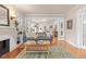 Bright living room featuring hardwood floors, a stylish sofa, and a decorative fireplace with built-in shelving at 2377 Cherry St, Denver, CO 80207
