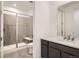 Modern bathroom with glass shower, tile surround, gray vanity, and a large mirror at 641 Sunrise St, Erie, CO 80516
