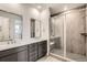 Modern bathroom featuring double vanity sinks and a tiled walk-in shower with a built-in bench at 641 Sunrise St, Erie, CO 80516