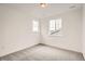 Bright, empty bedroom with gray carpet, white walls, and two windows that let in natural light at 641 Sunrise St, Erie, CO 80516