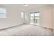 Bright bedroom featuring plush carpeting, neutral walls, and a sliding glass door to a patio at 641 Sunrise St, Erie, CO 80516
