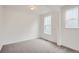 Carpeted bedroom with white walls and two windows providing natural light, and base trim at 641 Sunrise St, Erie, CO 80516