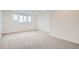 Spacious carpeted bedroom with neutral walls and a large window, offering a serene atmosphere at 641 Sunrise St, Erie, CO 80516