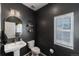 Stylish powder room with dark-painted walls and a pedestal sink at 16508 E 111Th Pl, Commerce City, CO 80022