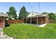 Large backyard with brick home, covered patio and neatly trimmed lawn is perfect for outdoor activities at 2549 Holly St, Denver, CO 80207