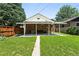 Backyard view of brick home with covered patio and manicured lawn is perfect for relaxing or entertaining at 2549 Holly St, Denver, CO 80207