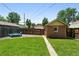 A beautiful backyard area with lush grass and a small brick outbuilding perfect for storage or a workshop at 2549 Holly St, Denver, CO 80207