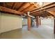Unfinished basement with brick support columns and exposed wood ceiling beams provides plenty of storage at 2549 Holly St, Denver, CO 80207