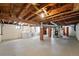 Spacious unfinished basement with concrete floors, wood beams and support columns at 2549 Holly St, Denver, CO 80207