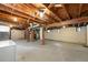 Unfinished basement showing exposed wood ceiling beams, concrete floors, and brick support columns at 2549 Holly St, Denver, CO 80207
