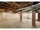 Spacious unfinished basement with brick support columns and laundry area awaits your personal design ideas at 2549 Holly St, Denver, CO 80207