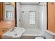 Tiled bathroom features a white vanity, shower-tub combo, glass block window and ample lighting at 2549 Holly St, Denver, CO 80207