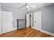 Bright bedroom featuring hardwood floors, a ceiling fan, and a gray dresser with ample closet space at 2549 Holly St, Denver, CO 80207