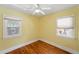 Bright bedroom showcasing wood floors, two windows, and sunny yellow walls at 2549 Holly St, Denver, CO 80207