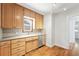 Well-lit kitchen with wood cabinets, stainless dishwasher, and classic tile backsplash at 2549 Holly St, Denver, CO 80207