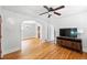 Bright living room features hardwood floors, a ceiling fan, and a decorative archway leading to the dining area at 2549 Holly St, Denver, CO 80207