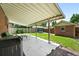 Covered patio with outdoor seating overlooks a fenced backyard with grass, landscaping and detached garage at 2549 Holly St, Denver, CO 80207