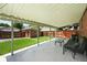 Covered patio with outdoor seating overlooks a fenced yard with detached garage and room to play at 2549 Holly St, Denver, CO 80207