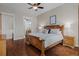 Bright bedroom with hardwood floors featuring a large wooden bed frame and ensuite bathroom access at 5149 Le Duc Ln, Castle Rock, CO 80108