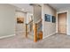 Carpeted hallway with a staircase, artwork and multiple doorways at 5149 Le Duc Ln, Castle Rock, CO 80108