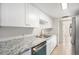 Bright kitchen with granite countertops, white cabinets, and stainless-steel appliances at 9700 E Iliff Ave # B13, Denver, CO 80231