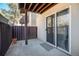 Private patio with sliding glass door access and wooden fence creating a cozy outdoor space at 9700 E Iliff Ave # B13, Denver, CO 80231