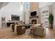 Inviting living room featuring a cozy fireplace, neutral furniture, and large windows for a light-filled space at 2130 Avenida Del Sol, Castle Rock, CO 80104
