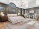Luxurious main bedroom with fireplace, sitting area, large windows, and decorative wall paneling at 2130 Avenida Del Sol, Castle Rock, CO 80104