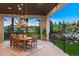 Covered outdoor dining area featuring wood table, overhead lighting, and a gorgeous view at 2130 Avenida Del Sol, Castle Rock, CO 80104