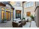 Cozy backyard patio area with a stone fireplace, cushioned outdoor furniture, and stone pavers at 2130 Avenida Del Sol, Castle Rock, CO 80104