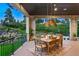 Inviting outdoor space, perfect for dining, features wood ceiling, stone columns and scenic views of lush greenery at 2130 Avenida Del Sol, Castle Rock, CO 80104