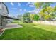 Green backyard with large lawn, a covered patio, and wood fence, offering a private outdoor space at 6545 S Balsam Ct, Littleton, CO 80123
