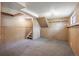 Unfinished basement with gray carpet, shelving and access to stairs, offering potential for customization at 6545 S Balsam Ct, Littleton, CO 80123