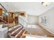 Open-concept living area with wooden staircase, neutral paint, a wine rack and natural light from a window at 6545 S Balsam Ct, Littleton, CO 80123