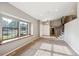 Bright and airy living space featuring a large window, carpet, and a clear view of the entryway and stairs at 6545 S Balsam Ct, Littleton, CO 80123