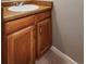 Close up of powder room vanity with wood cabinet and updated fixtures at 6545 S Balsam Ct, Littleton, CO 80123