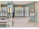 The bathroom features a soaking tub, a glass shower door, and double windows for natural light at 32 Silver Fox Cir, Greenwood Village, CO 80121