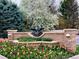 Elegant community entrance featuring a stone wall, colorful tulips, and a central eagle statue at 32 Silver Fox Cir, Greenwood Village, CO 80121