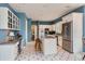 Spacious kitchen features white cabinets, stainless steel appliances, and a center island with stools at 32 Silver Fox Cir, Greenwood Village, CO 80121