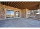 Covered stone patio with sliding glass doors and outdoor bench at 621 N Pines Trl, Parker, CO 80138