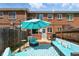 Outdoor seating area with turquoise cushions, umbrella, and barbecue grill at 1376 Ivanhoe St, Denver, CO 80220