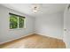 Bedroom with hardwood floors, white walls, ceiling fan, and large window at 1376 Ivanhoe St, Denver, CO 80220